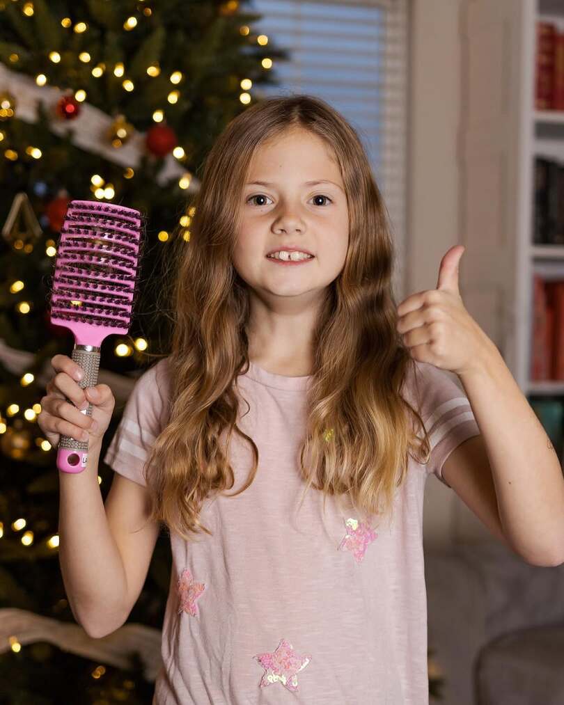 A parent brushing a child's hair calmly