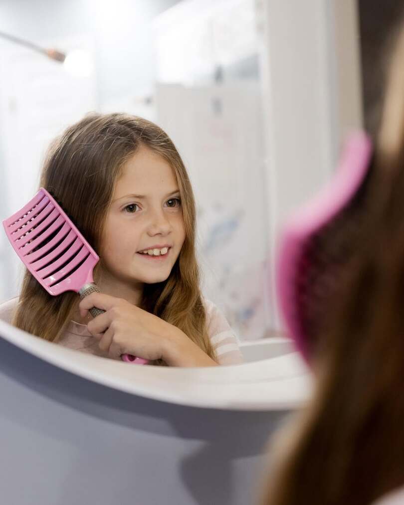 A child brushing their own hair